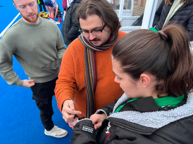 Hockey umpire exploring features of our watch app with our developers, Harry and Ethan.
